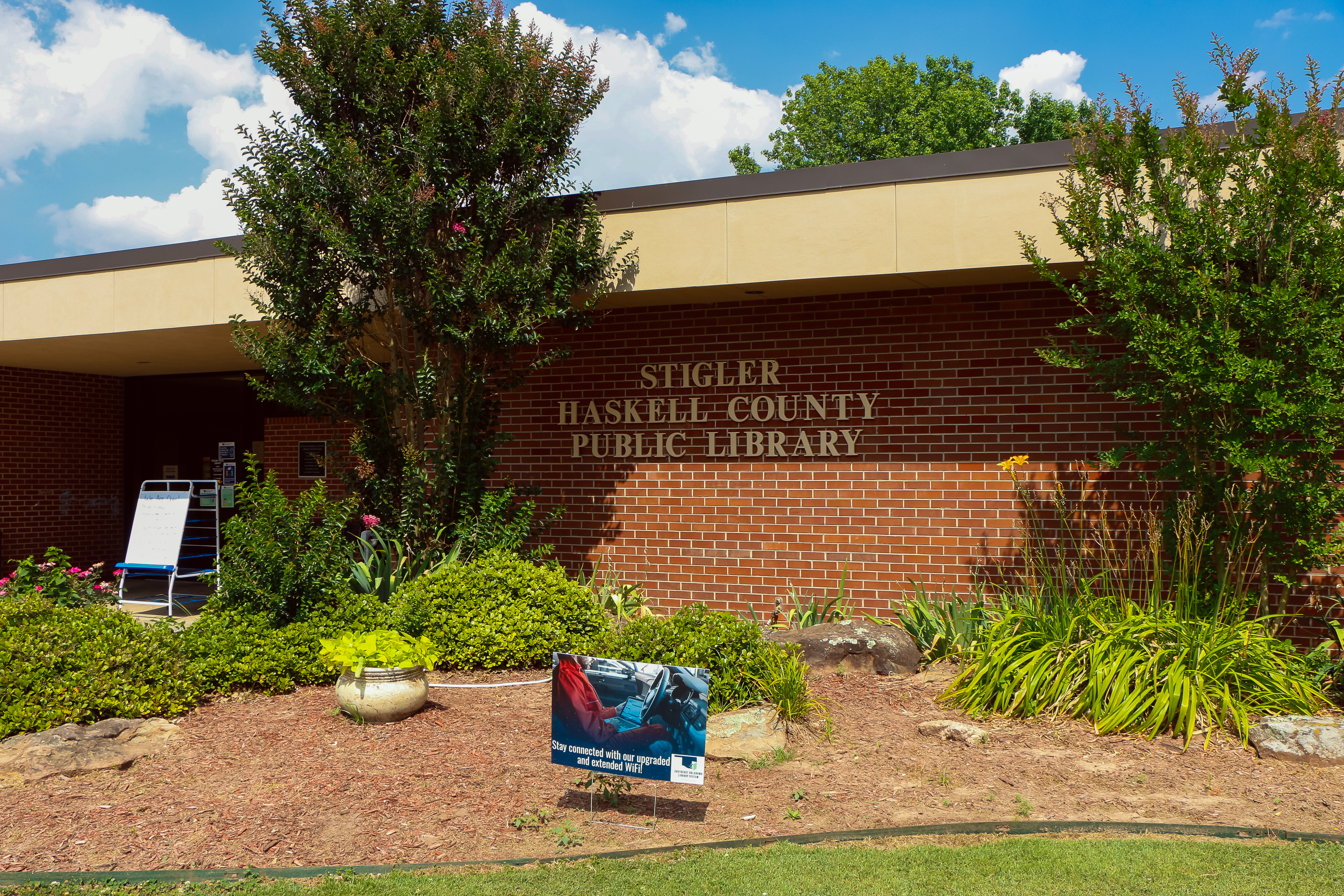 Photo of front of Stigler Public Library with garden visible.