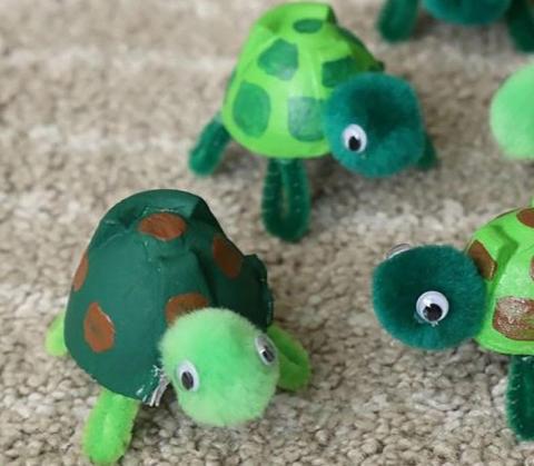 A turtle made out of an egg carton and pipe cleaners. 