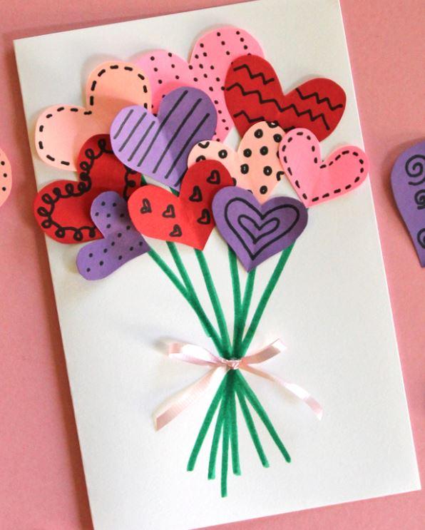 A valentine card made with cut-out hearts and a ribbon. 